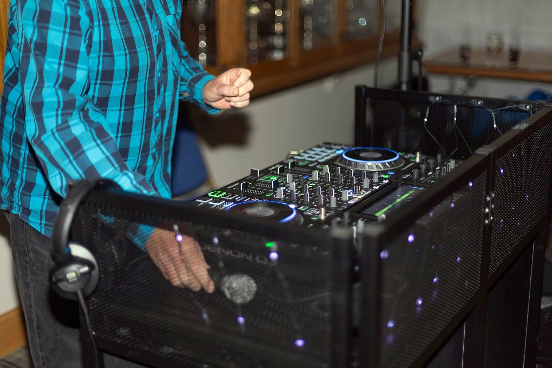 Hands on a DJ booth lit with starcloth
