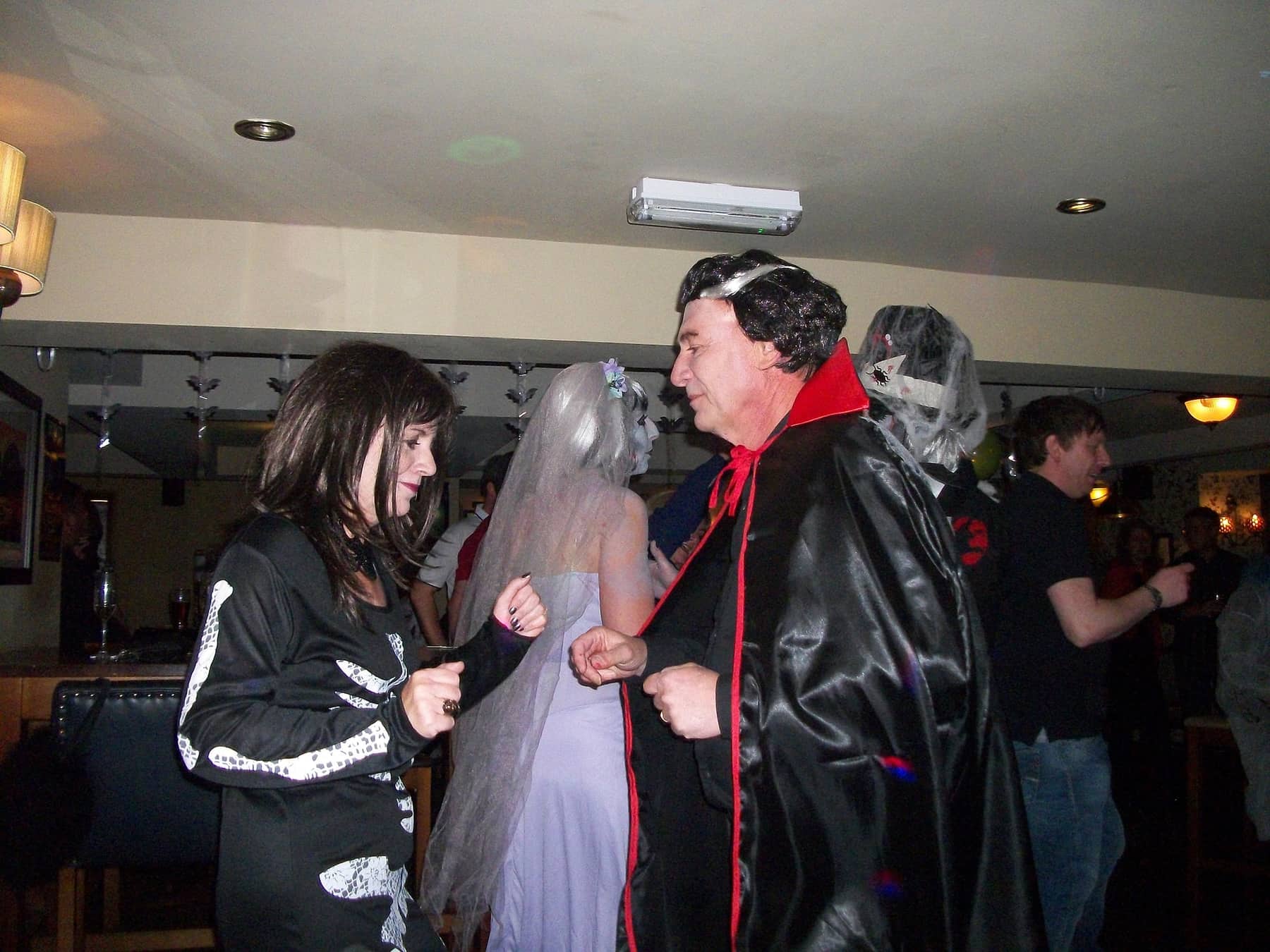 Party guests in Halloween costumes on the dance floor
