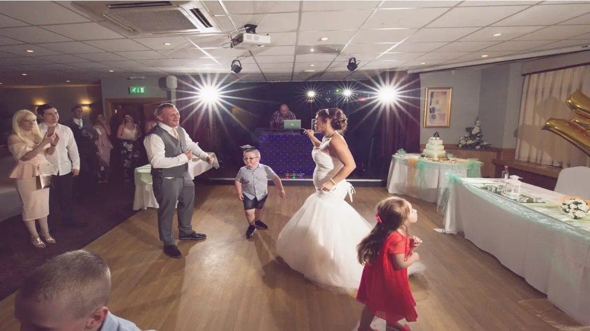 A bride dancing with two small children at the evening reception